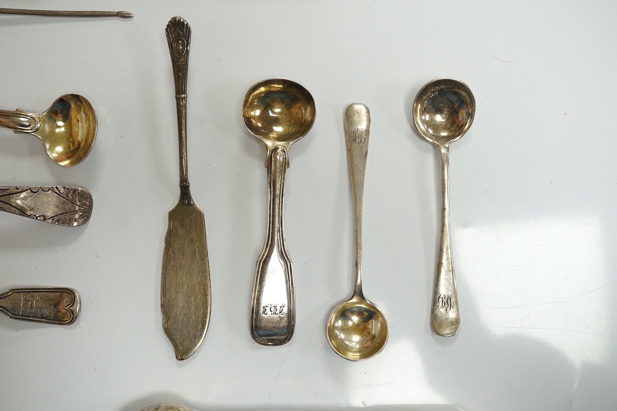 Ten assorted items of silver flatware including a mid 18th century mote spoon by Elizabeth Jackson?, 14.8cm, a George IV caddy spoons, two pairs of sugar tongs, four condiment spoons, a butter knife and sauce ladle, 6.8o